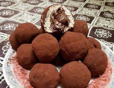 a plate topped with chocolate covered donuts on top of a table