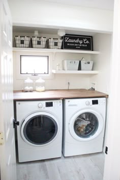 a washer and dryer in a small room with open shelving on the wall