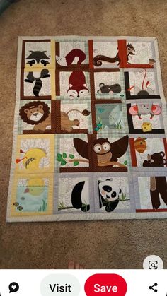 the quilt is on the floor and it has many different animals in squares around it