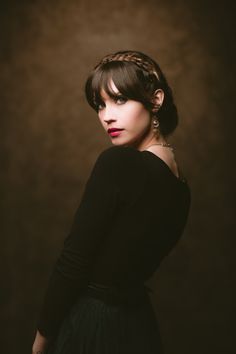 a woman in a black dress with her hair pulled back and wearing a leopard print headband