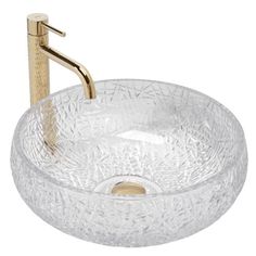 a glass bowl sink with a gold faucet on the side and a metal handle