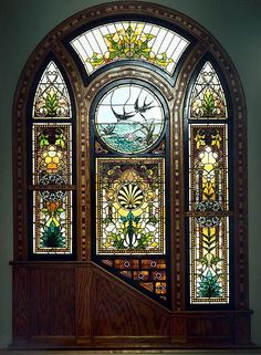 an ornate stained glass window in the corner of a room with stairs leading up to it