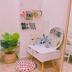 there is a vanity in the corner of this room with a potted plant next to it