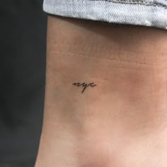 a small tattoo on the ankle that says mye in cursive writing,