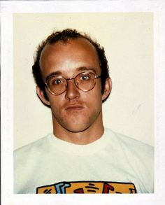 a man wearing glasses and a t - shirt with an image on the front is looking at the camera