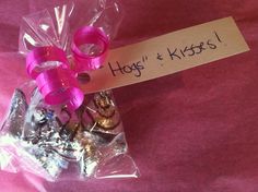 a pink ribbon wrapped in plastic on top of a bag filled with assorted candies