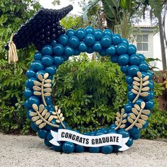 a graduation wreath made out of balloons in front of some bushes