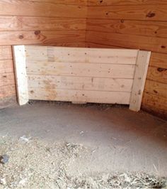 the inside of a horse stall with hay on the floor