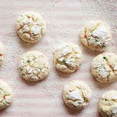 several cookies with sprinkles on a pink and white surface