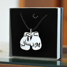 "◇ Make yourself feel like a champion by wearing this jewel. ◇ Simple yet powerful pendant that every athlete will love! Boxing gloves silver pendant with initial letter cut for personalization! ◇ Accompanied by a black leather cord 55cm, 60cm or 70cm. The choice is yours! ◇ The dimensions of the central element are 25mm (0.98 in) x 31mm (1.22 in) ◇ For all life winners! MATERIAL: ◇ High quality Solid 925 Silver, Rhodium plated ◇ Nickel Free ◇ Recycled 🏷️ DISCOUNT COUPON CODES 🛍️ By purchasing Initial Letter Necklace, Clothing Reference, Custom Initial Necklace, Monogram Necklace, Custom Initials, Boxing Gloves, Personalized Monogram, Initial Letter, Make Yourself