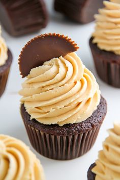 chocolate cupcakes with peanut butter frosting in the middle on a white surface