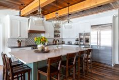 a large kitchen with an island in the middle and lots of stools around it