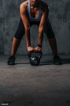 a woman squatting down while holding a kettle