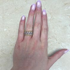 a woman's hand with pink manicures and a ring on her finger