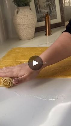 a woman is rolling out rolled up pasta on the counter top with her hands and fingers