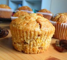 some muffins sitting on top of a wooden table next to raisins