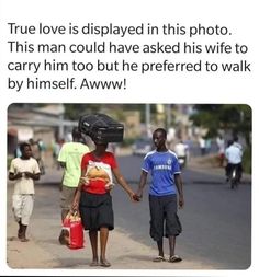 two boys walking down the street holding hands with another boy who is wearing a helmet on his head