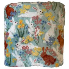 a blanket with rabbits and flowers on it