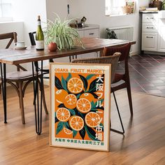 an orange poster sitting on top of a wooden table next to a potted plant