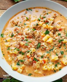 a white bowl filled with pasta and meat soup