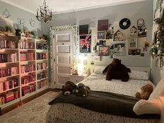 a bedroom with bookshelves and stuffed animals on the bed in front of it