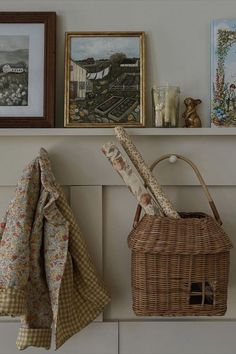 there is a basket on the shelf next to some pictures and other things in front of it