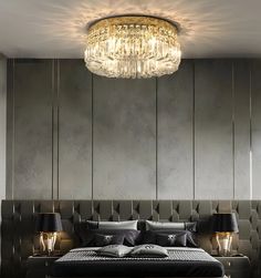 a bedroom with a large bed and chandelier hanging from it's ceiling