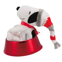 a stuffed dog in a red hat and scarf on top of a metal bowl with its mouth open