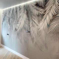 the wall is decorated with palm leaves and has white paint on it, along with wooden flooring