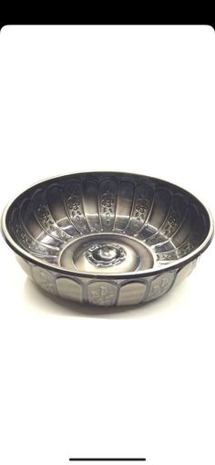 a silver bowl sitting on top of a white table