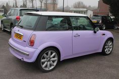 a small purple car parked in a parking lot