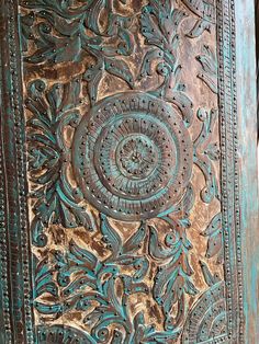 an ornate wooden door with blue paint on it