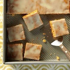 there are squares of cake with icing on the pan