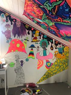 a room filled with lots of colorful paintings on the wall and ceiling covered in graffiti