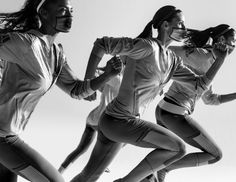 three women are running in the air with their arms around each other and one is wearing headphones