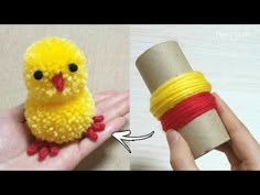 a small yellow bird sitting on top of a piece of yarn next to a roll of thread