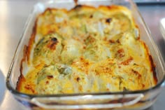 a casserole dish with broccoli and cheese in it on a table