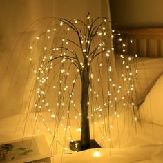 a lighted tree is sitting on a bed