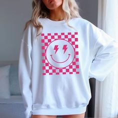 Spread joy and style with our Checkered Smiley Graphic T-Shirt or Sweatshirt! Featuring a playful checkered smiley face, this piece adds a fun twist to your casual wardrobe. Available as both a t-shirt and a sweatshirt, it's perfect for any season. The high-quality fabric ensures comfort and durability, while the unique design makes it a standout choice for everyday wear. Whether you're dressing up for a casual outing or lounging at home, this checkered smiley graphic piece is sure to bring a sm Casual Smiley Face T-shirt, Checkered Smiley Face, Smiley Shirt, Smiley Graphic, Pink Smiley, Smiley Face Shirt, Pink Checkered, Wild Honey, Color Charts