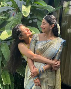 two women in sari hugging each other