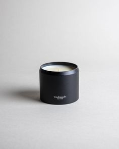 a black candle sitting on top of a white table