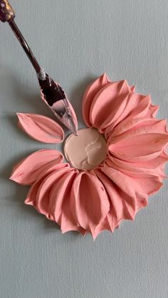 a pink flower with a paintbrush sticking out of it