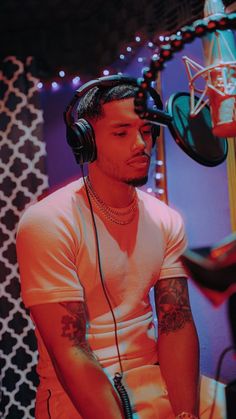 a man wearing headphones sitting in front of a microphone