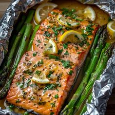 salmon and asparagus on foil with lemons, parsley and seasoning