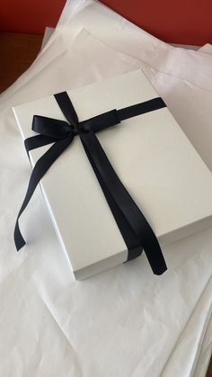 a white box with a black ribbon on it