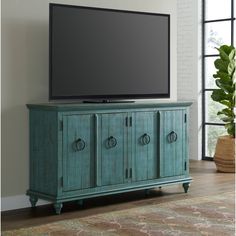 a flat screen tv sitting on top of a wooden cabinet