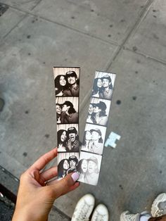 someone is holding up some photos on the street