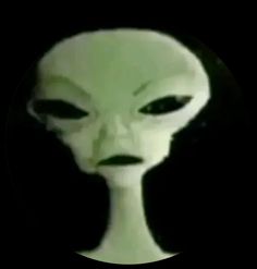 an alien head is shown in the middle of a black background with a white circle around it