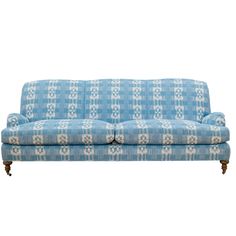 a blue and white patterned couch with wooden legs