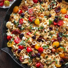 pasta salad with tomatoes, olives, and feta cheese in a skillet